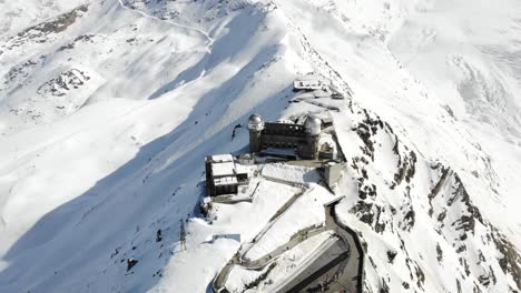 Aerial-flyover-over-Gornergrat-train-station-with-pan-up-towards-the-mountains