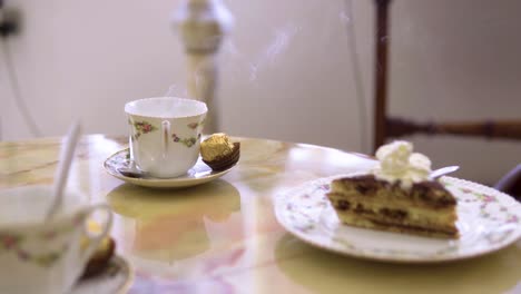 freshly-prepared-cup-of-coffee-with-a-lot-of-smoke-coming-out-of-it-served-with-cake-cream-on-top-slow-motion
