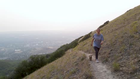 Mujer-Y-Cachorro-Caminando-Por-Una-Ruta-De-Senderismo-Al-Aire-Libre-En-Las-Montañas-De-Utah
