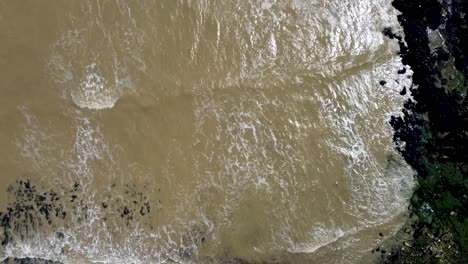 Over-head-drone-video-4K-footage-of-waves-coming-over-the-rocks