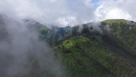 Wide-drone-shot-through-the-clouds-of-a-small-village-on-a-mountain-top-in-Tusheti-Village-in-Georgia