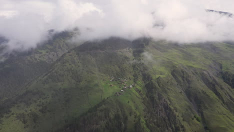 Cinematic-descending-drone-shot-through-the-clouds-of-a-small-village-on-a-mountain-top-in-Tusheti-Village-in-Georgia
