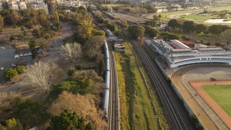 Aerial-tracking-shot-of-driving-train-in-direction-Buenos-Aires-Central-during-sunny-day-in-Argentina
