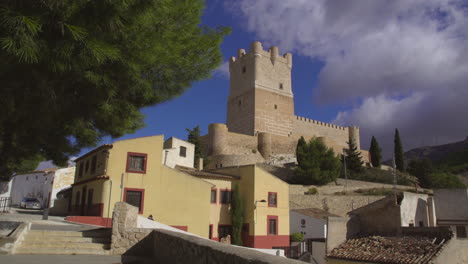 Low-angle-time-lapse-view-of-The-Atalaya-Castle-making-incredible-view-with-clouds-is-moving-under-the-blue-sky,-Villena,-Province-of-Alicante,-southern-Spain