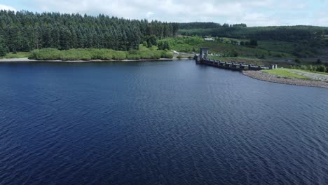 Alwen-reservoir-Welsh-woodland-lake-water-supply-aerial-view-concrete-dam-countryside-park-wide-left-orbit