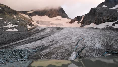 Luftüberführung-Bei-Sonnenuntergang-über-Den-Gletschersee-Und-Das-Eis-Zu-Den-Glühenden-Gipfeln-Hinter-Dem-Witenwasserengletscher-In-Uri,-Schweiz