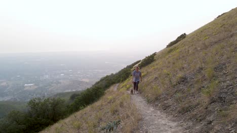 Mujer-Caucásica-Y-Cachorro-De-Garabato-Caminando-Por-Senderos-En-Las-Montañas-De-Utah