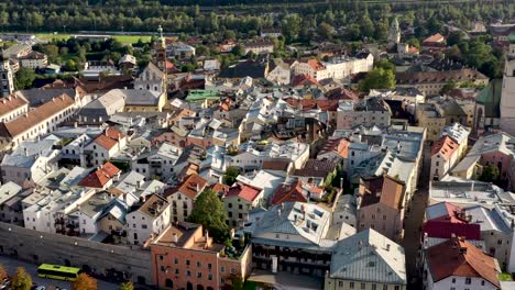 Aerial-view-of-mountain-town-of-Austria-with-churches,colorful-houses,-tower,-autumn-scenery-at-sunset,-river-Austrian-Alps-,-Austria,-Europe