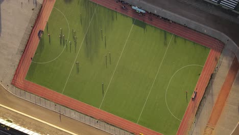 Aerial-birds-eye-shot-of-hockey-match-on-green-hockey-court-during-sunny-day-in-Buenos-Aires,Argentina