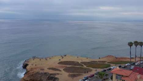 Aerial-approaching-of-unrecognizable-people-at-Sunset-Cliffs,-California