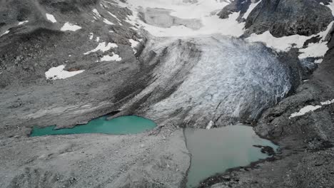 Aerial-flyover-towards-the-Witenwasseren-glacier-with-a-pan-up-from-its-glacial-lake-in-Uri,-Switzerland