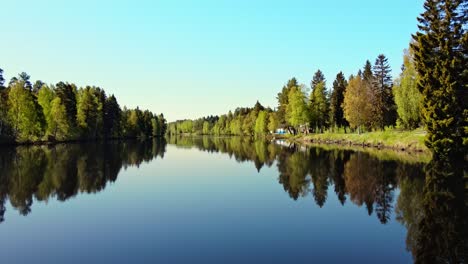 Lush-Trees-Reflection-On-Transparent-Water-Of-River-Vasterdalalven-In-Vansbro,-Dalarna-County,-Sweden