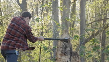 Young-Caucasian-man-working-at-chopping-down-a-tree-stump