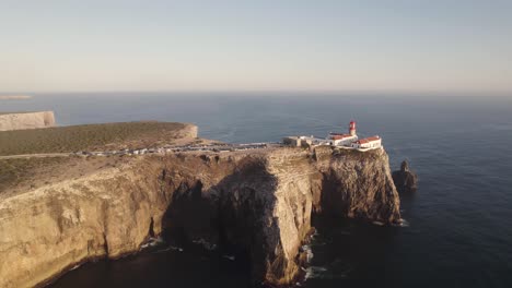 Cinematic-aerial-shot-of-Cape-Saint-Vincent-lighthouse-on-eroded-high-cliff-surrounded-by-Atlantic-Ocean