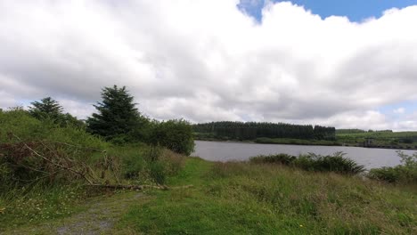 Zeitraffer-Des-Sonnigen-Alwen-Reservoirs-Schnelle-Wolken,-Die-über-Das-Riesige-Blaue-Waldseewasser-In-Richtung-Kamera-Ziehen