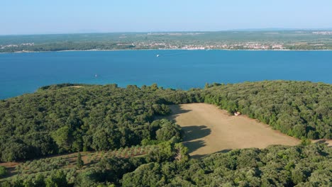 Aerial-shot-over-the-island-of-Brijuni,-Croatia-looking-across-the-Fazana-strait-to-the-mainland