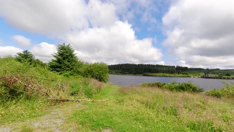 Sonniger-Alwen-Reservoir-Im-Zeitraffer-Schnelle-Wolken,-Die-über-Das-Riesige-Blaue-Waldseewasser-Zum-Betrachter-Ziehen