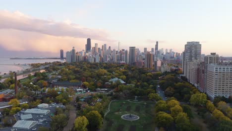 Amazing-Aerial-Establishing-Shot-Above-Park-Chicago-Skyline-in-Background-Sunset