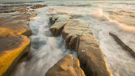 Powerful-Ocean-Waves-Breaking-On-Rocky-Outcrops-At-The-Beach-In-San-Diego-On-A-Sunset