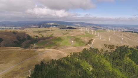 Aerial-fly-in-to-a-2-propellor-wind-farm-in-Manawatu,-New-Zealand