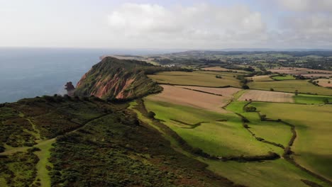 Aerial-View-Of-Rolling-Green-Idyllic-Countryside-Landscape-Beside-English-Channel-In-Devon
