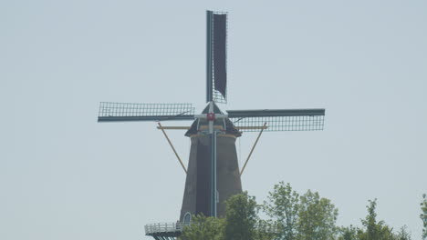Medium-shot-of-classical-Dutch-windmill-with-spinning-blades