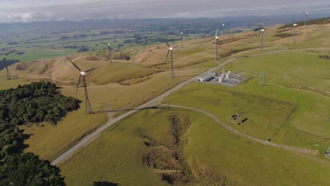 Drone-flying-over-wind-farm-area-with-mini-substation-below