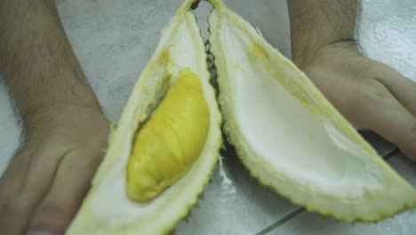 Mannhände-öffnen-Die-Hälfte-Des-Mao-Shan-Wang-Durian---Nahaufnahme