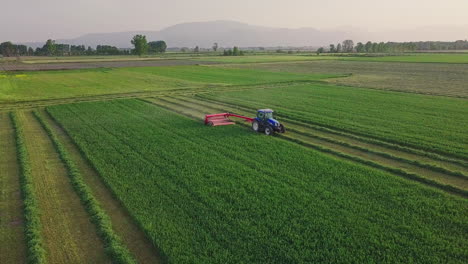 Aerial-shot-of-tractor-driving-through-field-while-harvesting,-4K