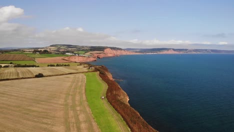 Aerial-Over-Farmland-Countryside-Landscape-Beside-English-Channel-In-Devon