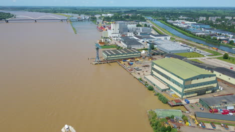 Aerial-of-construction-company-with-large-cranes-located-near-river
