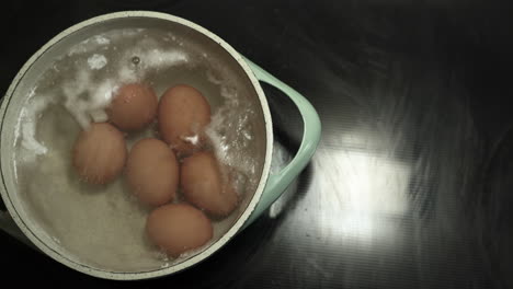 Eier-Werden-In-Einem-Topf-Mit-Kochend-Heißem-Wasser-Mit-Etwas-Schaum-Oben-Drauf-Gekocht