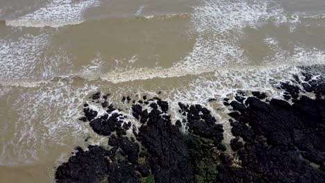 4K-drone-video-of-the-sea-coming-into-shore-over-rocks