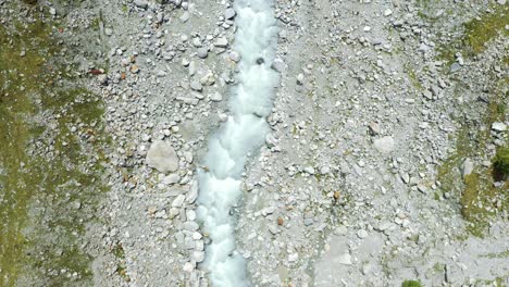 Vuelo-De-Drones-Sobre-Un-Sinuoso-Río-Glaciar-A-Través-De-Un-Valle-Alpino-De-Alta-Montaña
