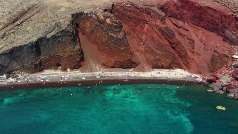 Luftaufnahme-Von-Oben-Nach-Unten,-Die-Den-Berühmten-Roten-Strand-Mit-Türkisfarbenem-Wasser-Und-Rotem-Sand-Auf-Santorini,-Griechenland,-Enthüllt