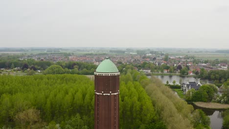 Luftbahn-über-Dem-Berühmten-Wasserturm-In-Der-Stadt-Axel,-Aufgenommen-An-Einem-Bewölkten-Tag-Mit-Stadt-Im-Hintergrund