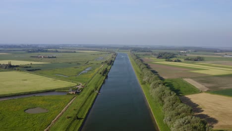 Aerial-shot-of-the-Canal-through-Walcheren-and-surrounding-agricultural-land-in-Zeeland,-the-Netherlands,-on-a-sunny-summer-day