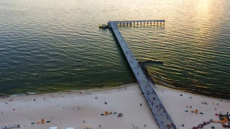 Aerial-Top-View-Of-Sea-Bridge-In-Palanga,-Lithuania-During-Sunset---drone-shot