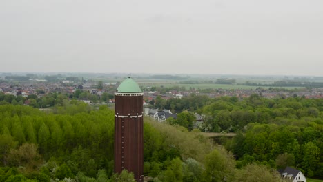 Aerial-orbit-over-the-famous-water-tower-in-the-city-of-Axel-shot-on-a-cloudy-day-with-city-panorama-in-behind