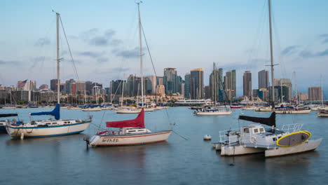 Boats-Anchored-In-Harbour-And-Skyscrapers-In-Background---timelapse-zoom-in