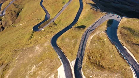 Aerial-view-of-motorcyclists-riding-Fuscher-Torl-pass-on-Grossglockner-scenic-High-Alpine-Road,-Austria