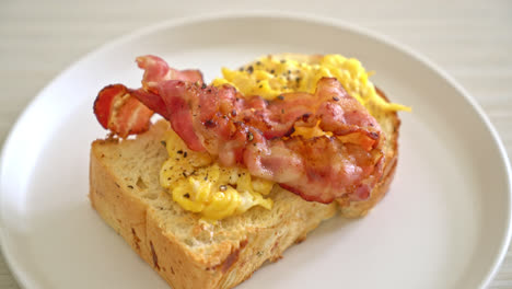 bread-toast-with-scramble-egg-and-bacon-on-white-plate
