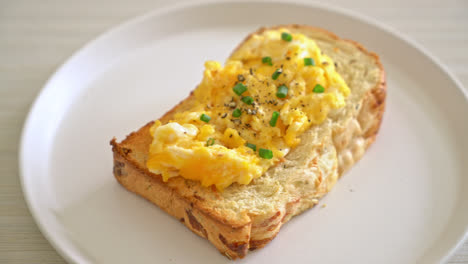 bread-toast-with-scramble-egg-on-white-plate