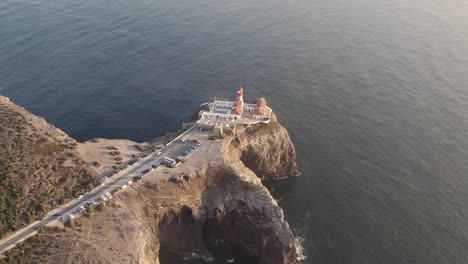 Cinematic-aerial-seascape-of-Cabo-de-Sao-Vicente-lighthouse-on-top-of-rugged-cliff-surrounded-by-Atlantic-Ocean