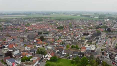 Aerial-descending-shot-of-the-Axel-city-center-in-the-Netherlands-shot-on-a-cloudy-day-with-foggy-background