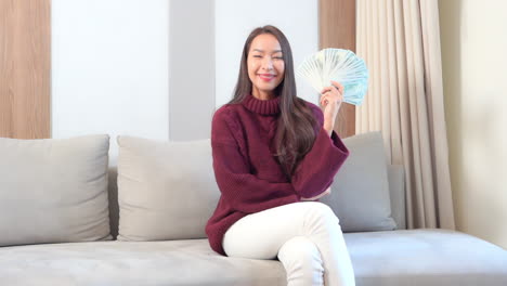 Sexy-exotic-woman-posing-to-camera-with-hand-full-of-cash-dollar-money,-lottery-winning-concept,-full-frame-slow-motion