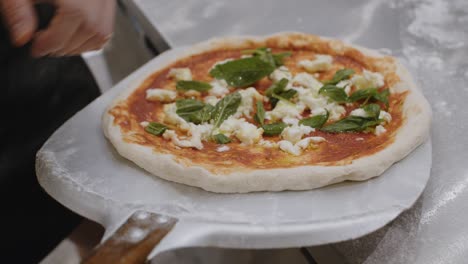 Stretching-prepared-neapolitan-pizza-on-top-of-peel