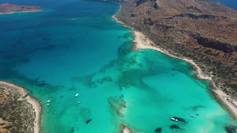Aerial-panning-up-and-revealing-Balos-Beach-and-Lagoon-with-turquoise-water,-mountains-and-cliffs-in-Crete,-Greece