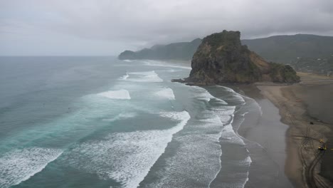 View-of-the-famous-iconic-Lion-Rock-formation-in-Piha,-New-Zealand-on-cloudy-overcast-day-in-4K