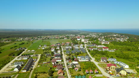 Rural-town-in-Northern-Poland-on-clear-summer-day,-aerial